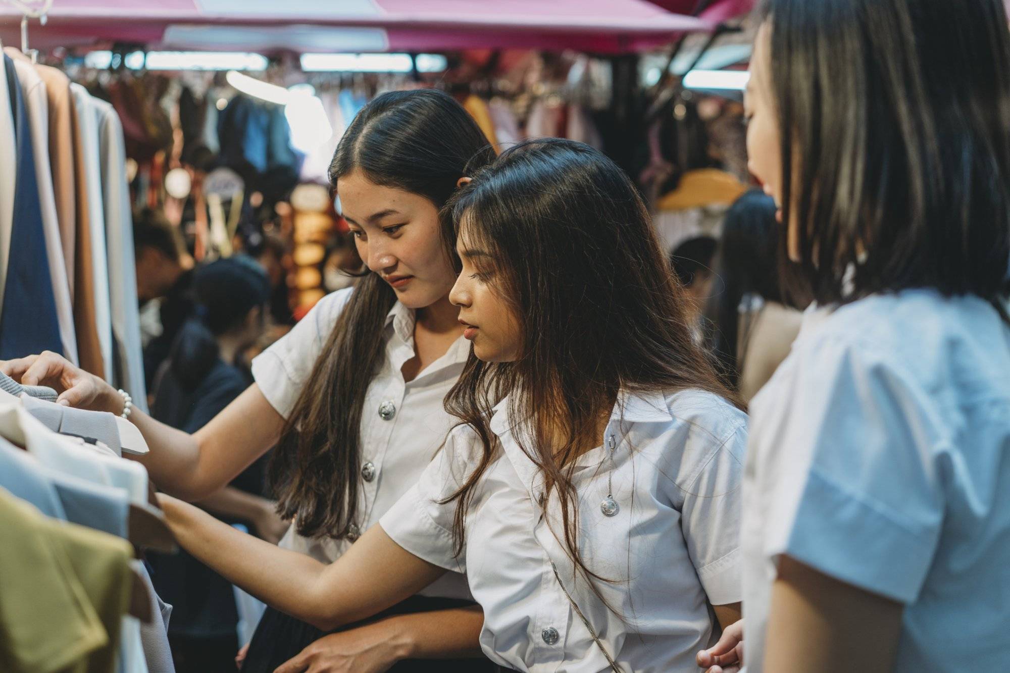 Three student friends doing shopping at the night market in the city Three student friends doing shopping at the night market in the city