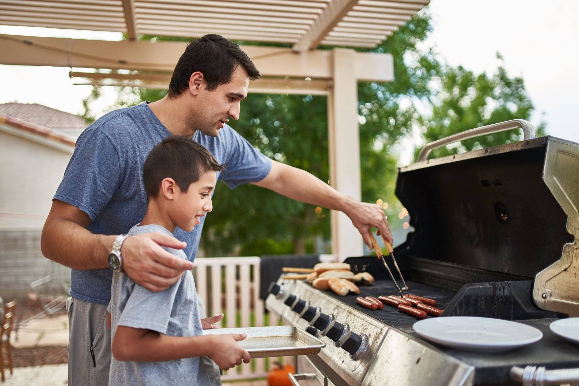 father teaching son how to grill hot dogs and bonding father teaching son how to grill hot dogs and bonding