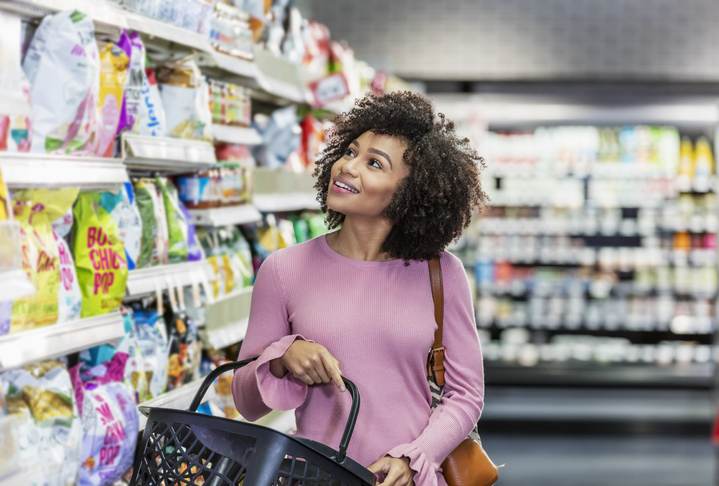Young African-American woman shopping in supermarket