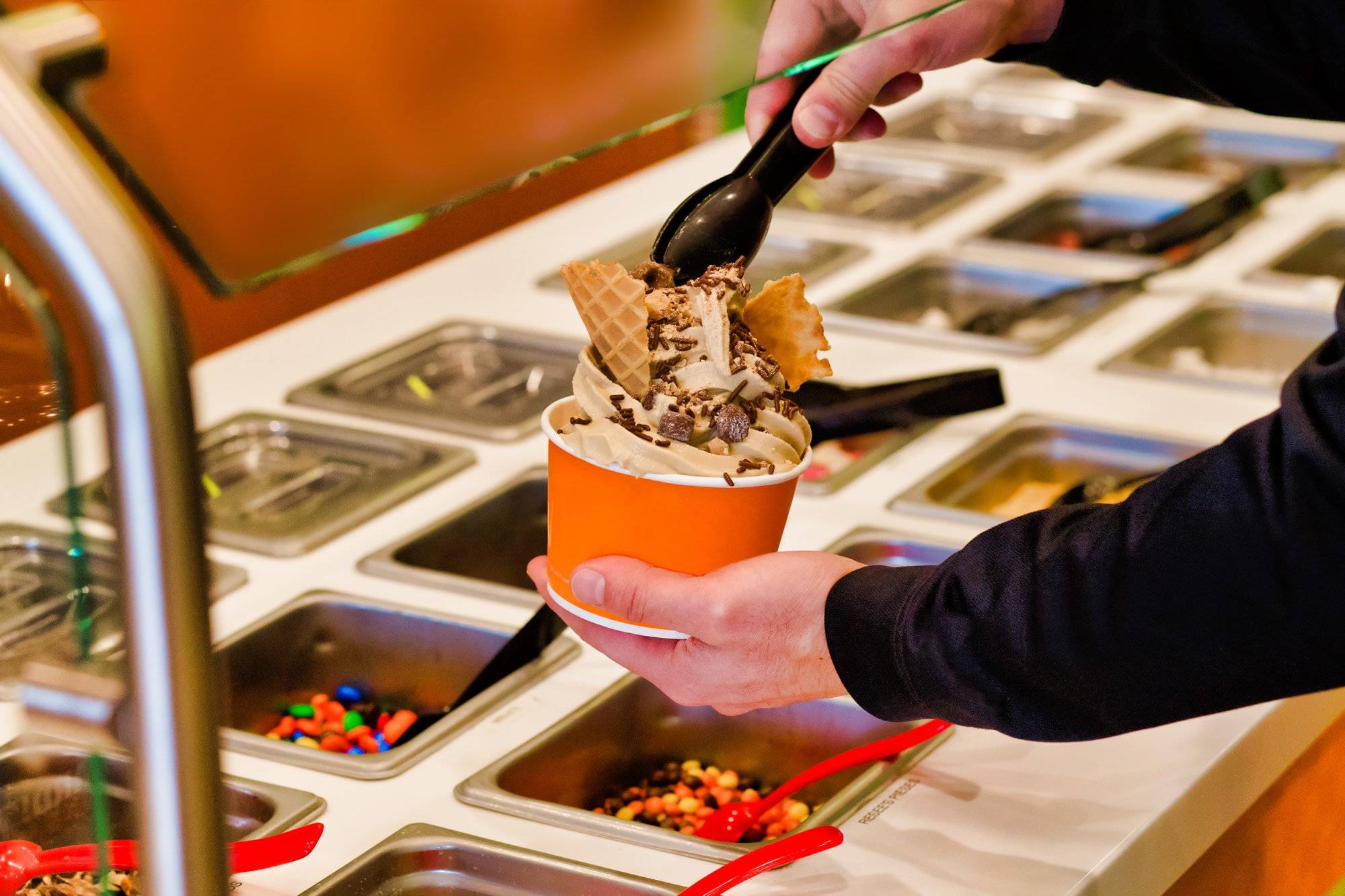 Making frozen yogurt with chocolate chips and sprinkles at the buffet Making frozen yogurt with chocolate chips and sprinkles at the buffet