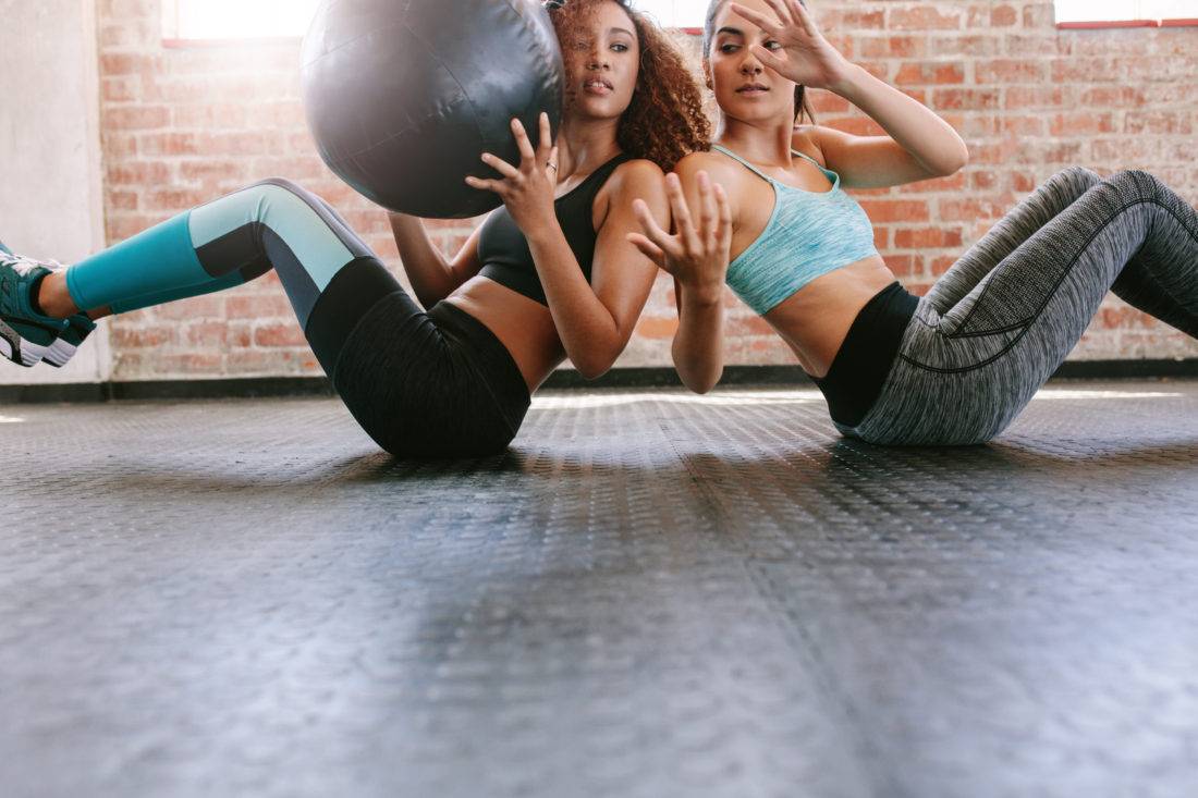 Girls working out in gym with medicine ball Girls working out in gym with medicine ball
