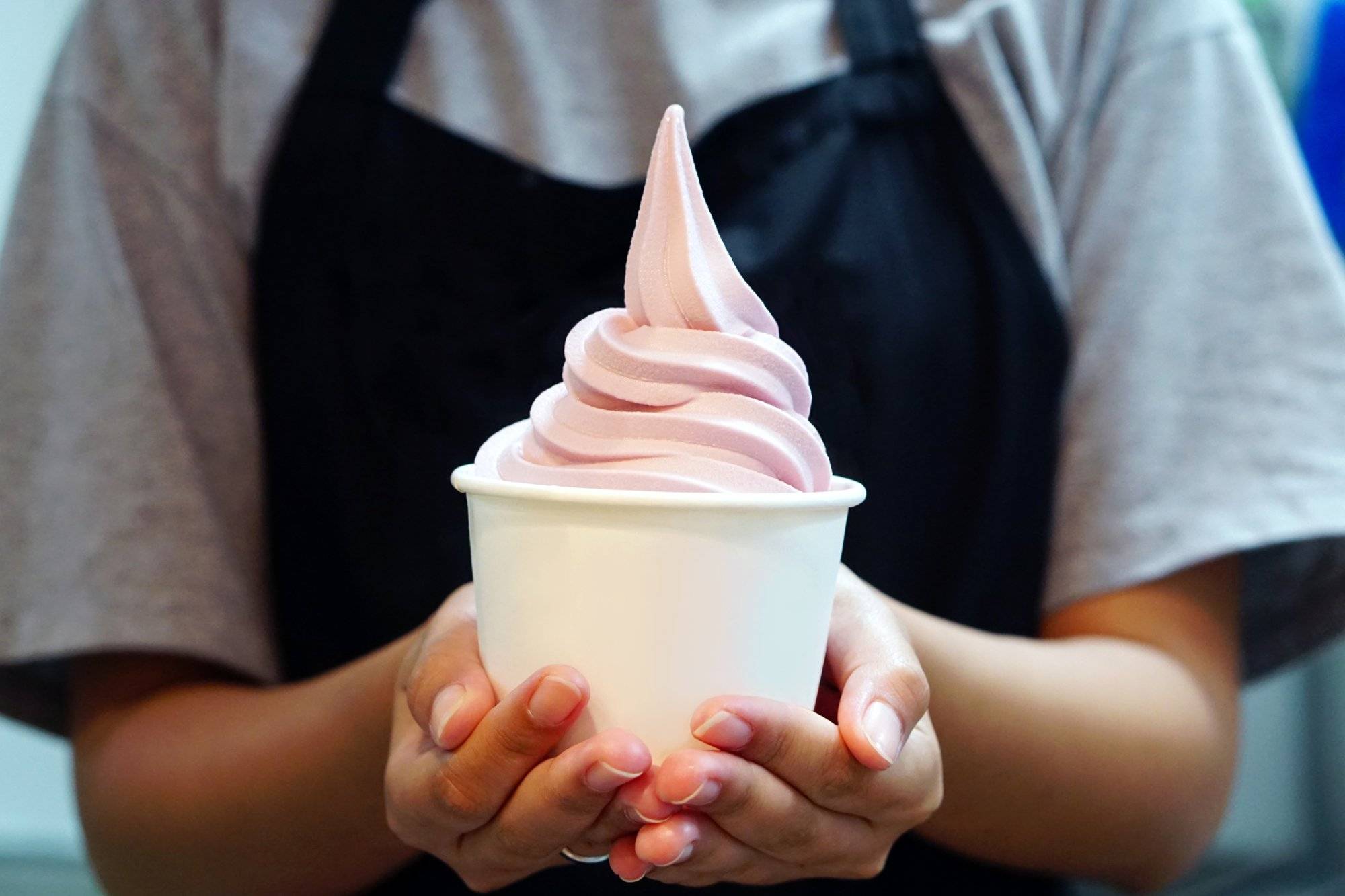 Closeup of woman 's hand holding takeaway cup with organic frozen yogurt ice cream, It's delicious and healthy enjoy eating concept.