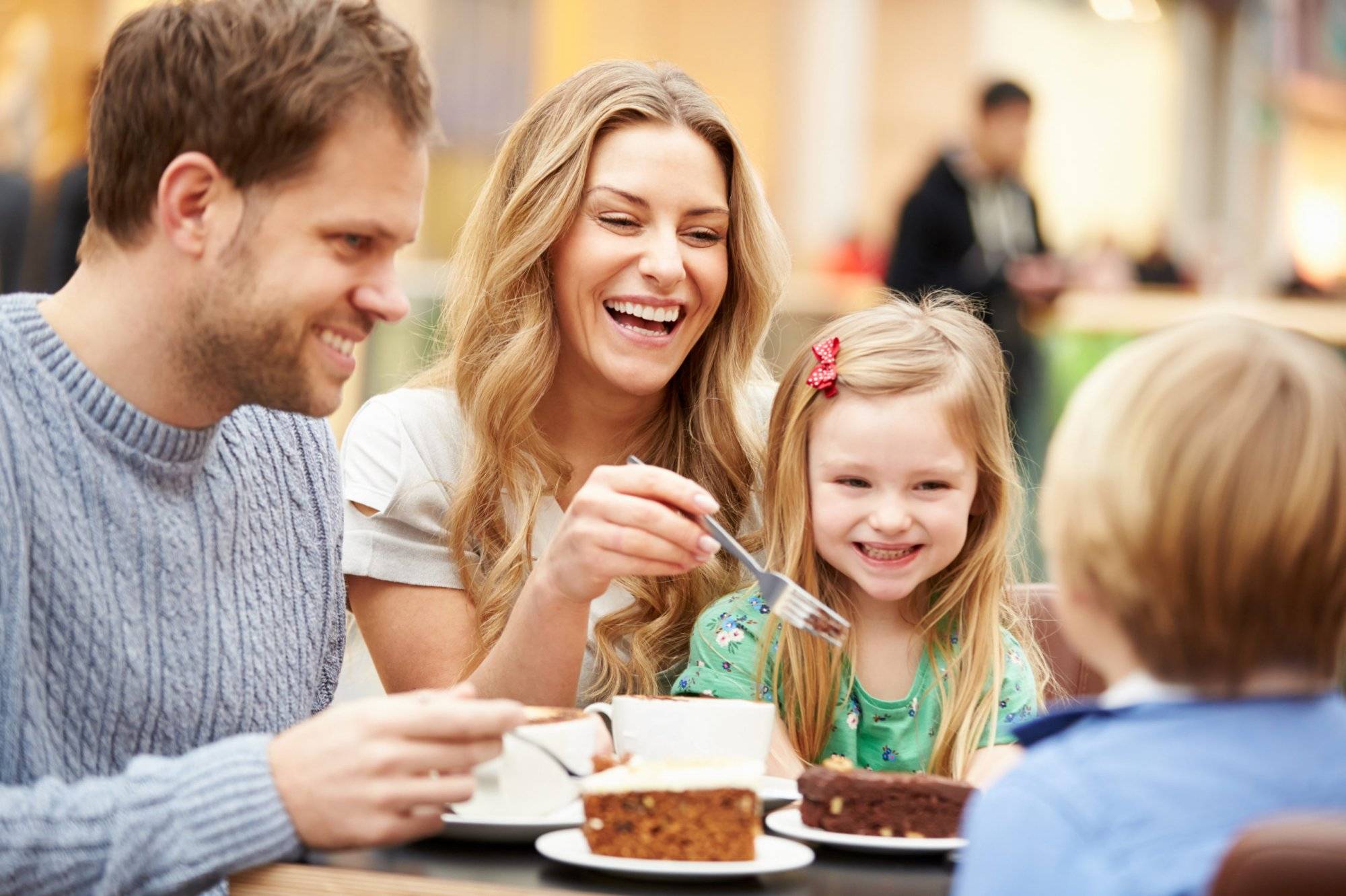 Family Enjoying Snack In Café Together